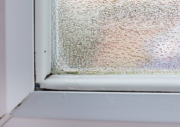 Condensación se reúne en la esquina de una ventana de doble acristalamiento después de la noche fría que puede causar problemas de moho y salud - Foto, Imagen