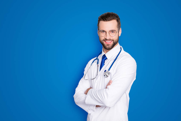 Portrait with copy space of cheerful joyful doc with bristle in white lab coat and stethoscope on his neck, having his arms crossed, looking at camera, isolated on grey background. - Foto, afbeelding