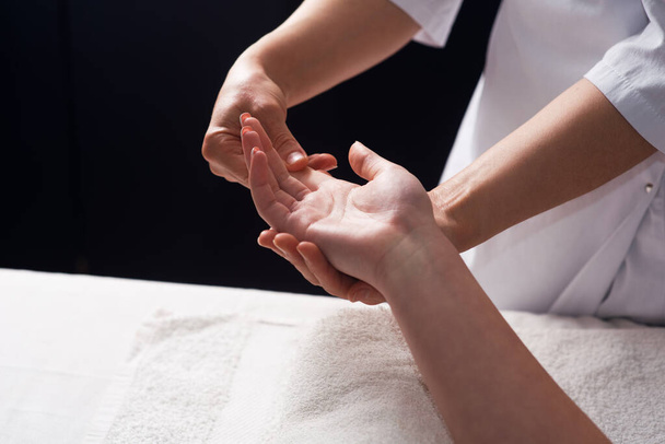 Masseur doing hand massage with oil in spa salon. Spa procedures. relaxing, wellness hand massage. Body care concept. Close-up view. Female hand close-up - Fotó, kép