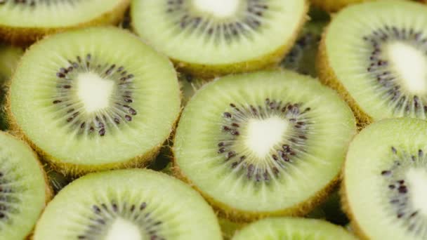 Πράσινο ακτινίδιο φέτες φρούτων Περιστρέφεται αργά σε μαύρο φόντο. Φρέσκα και ζουμερά - Πλάνα, βίντεο