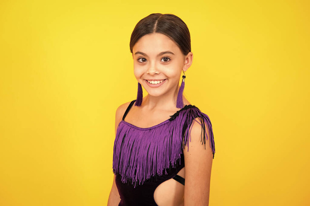 Portrait of beautiful happy smiling teenage girl on yellow studio background - Photo, Image