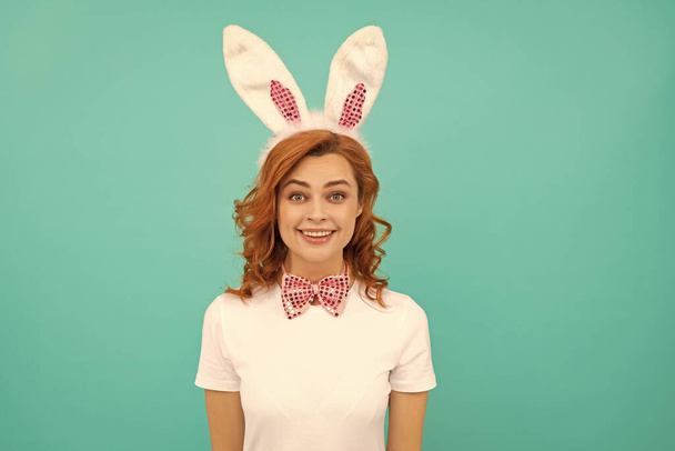 cheerful easter girl in bunny ears and bow tie on blue background. - Valokuva, kuva