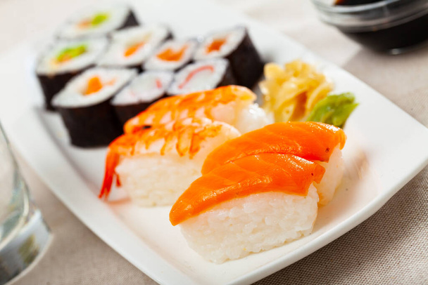 Fresh sushi maki and nigiri served on white plate with wasabi and soy sauce - Photo, image