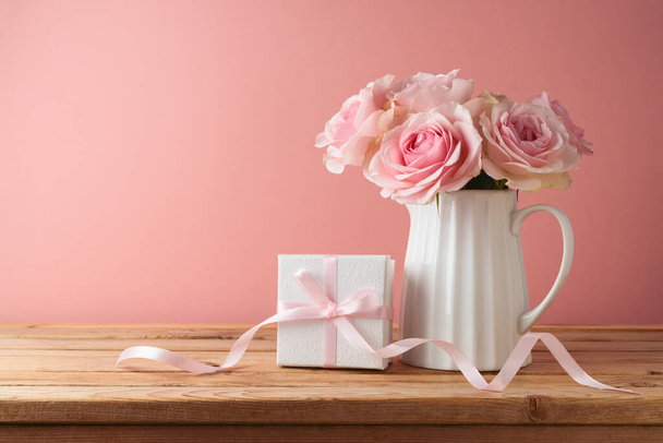 Happy Mother's day concept with rose flowers and gift box on wooden table over pink background - Foto, Imagen
