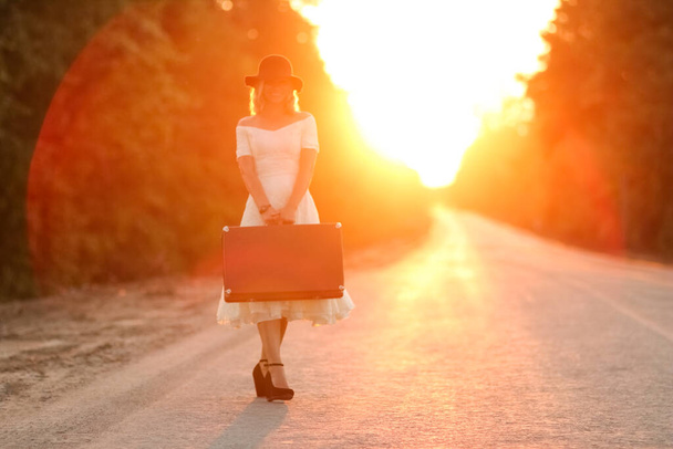 vintage girl with hat with a suitcase hitchhiking - Fotografie, Obrázek