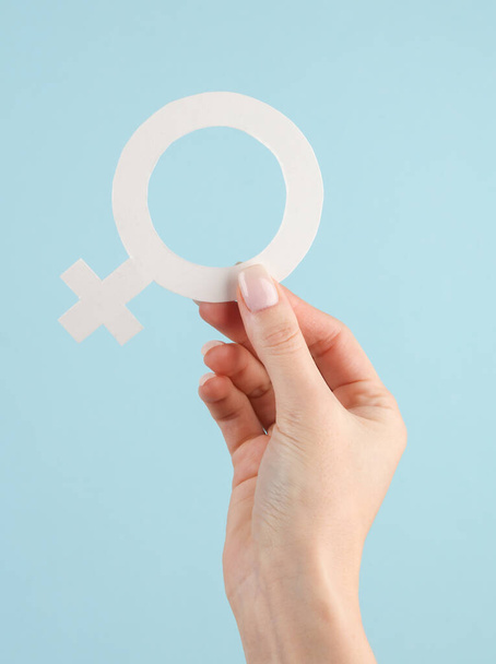Gender symbol of venus in a female hand on blue background. Feminism. Women's power - Photo, Image