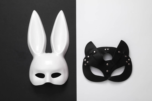 Sex shop white and black masks on a white-black paper background - Fotoğraf, Görsel