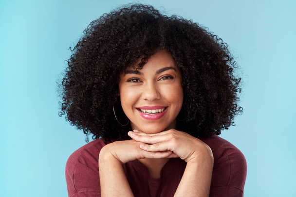 Sei vor allem glücklich. Studioporträt einer attraktiven jungen Frau, die vor blauem Hintergrund posiert - Foto, Bild