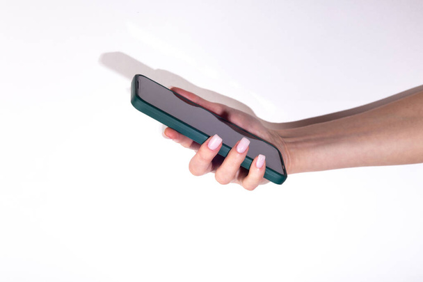 Ręka kobiety za pomocą smartfona na białym tle - Zdjęcie, obraz