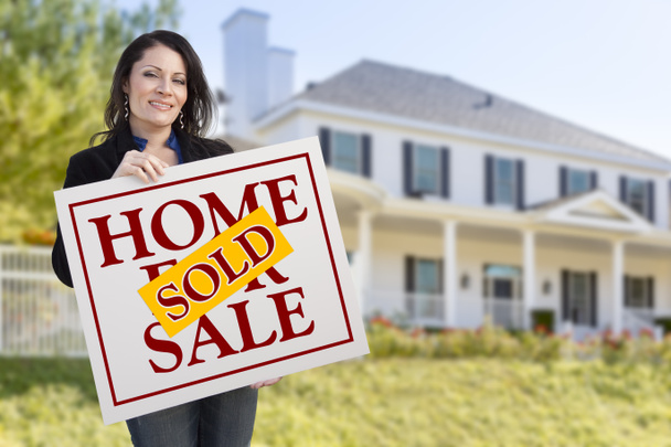 Woman Holding Sold Home Sale Sign in Front of House - Photo, Image