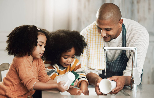 Happy, cleaning and father with children in kitchen for bonding, hygiene or teaching. Smile, support and chores with black family washing dishes at home for sanitary, responsibility or housekeeping. - Photo, Image