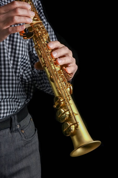 soprano saxophone in hands on a black background - Foto, Imagem