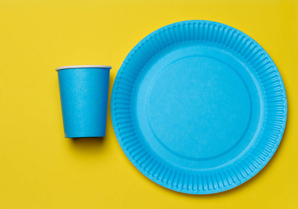 Kulaté jednorázové modré papírové talíře a šálky na piknik, recyklovatelný odpad, horní pohled. - Fotografie, Obrázek