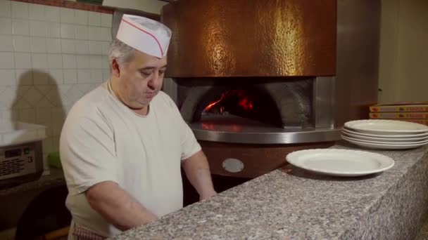 イタリアン レストランのキッチンの料理の準備でピザを作る男料理 - 映像、動画