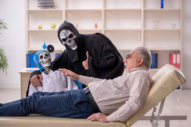 Viejo paciente visitando a dos doctores diablo - Foto, imagen