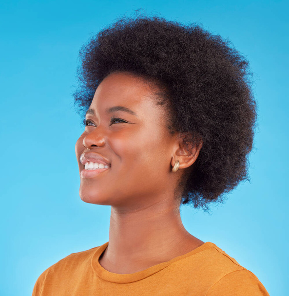 Thinking, smile and happy black woman wondering looking away in thought isolated against a blue studio background. Afro, casual and face of young African American female relax, calm and confident. - Zdjęcie, obraz