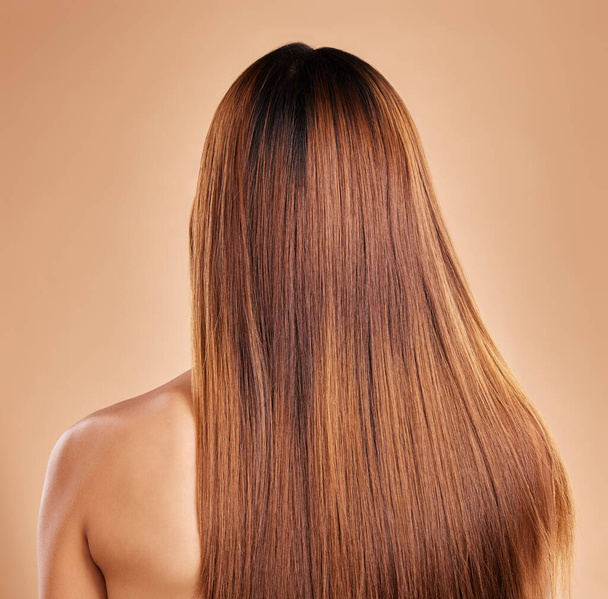 Haircare, beauty and back of woman with straight hair in studio isolated on brown background. Balayage, wellness and female model with salon treatment for growth, keratin texture or healthy hairstyle. - Foto, afbeelding