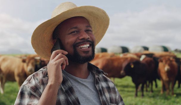 Cuanto más se conecta, más grande es el crecimiento. un hombre maduro usando un teléfono inteligente mientras trabaja en una granja de vacas - Foto, imagen