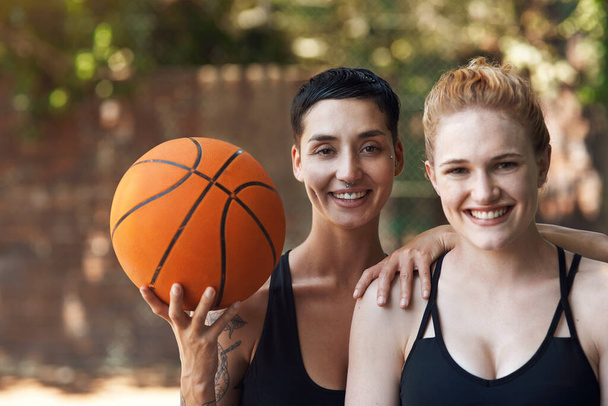 Meillä on peli... ja pallo. Rajattu muotokuva kaksi viehättävää nuorta naisurheilijaa seisoo yhdessä koripallokenttä - Valokuva, kuva