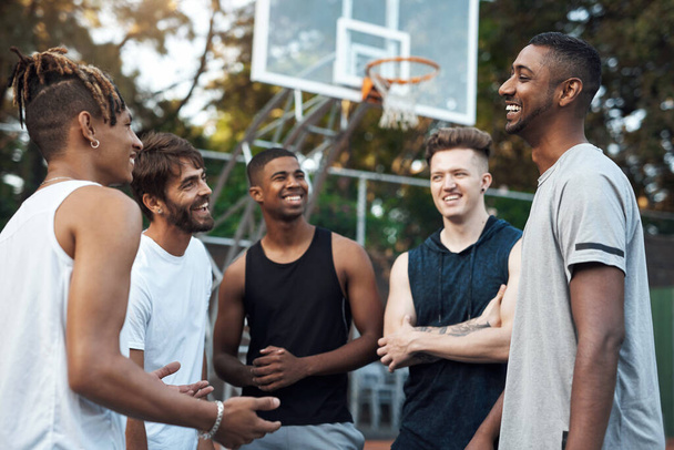Ta hra byla jedna z nejnapínavějších. skupina sportovních mladých mužů, kteří se poflakují na basketbalovém hřišti - Fotografie, Obrázek