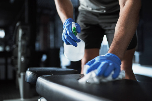 A new standard of gym safety. an unrecognisable man disinfecting the surfaces in a gym - Foto, Imagem
