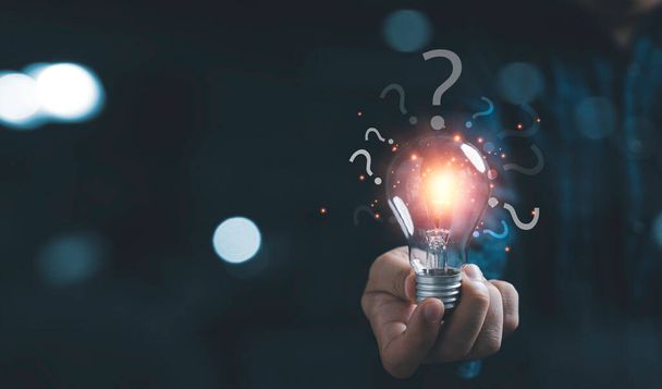 Businessman holding glowing lightbulb and question mark with copy space for creative thinking idea and problem solving concep - Φωτογραφία, εικόνα