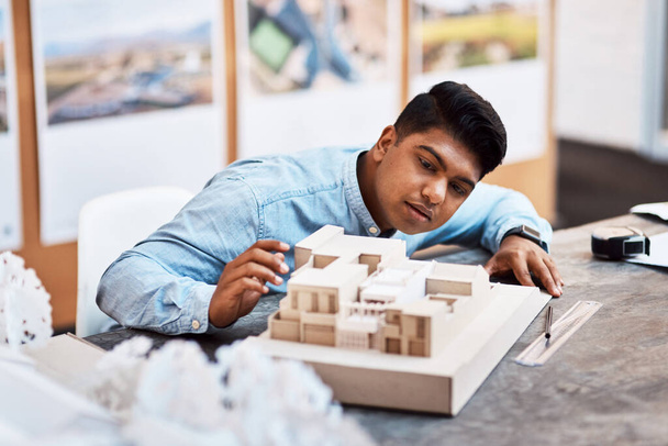 O menor detalhe pode fazer a diferença. um jovem arquiteto projetando um modelo de edifício em um escritório moderno - Foto, Imagem