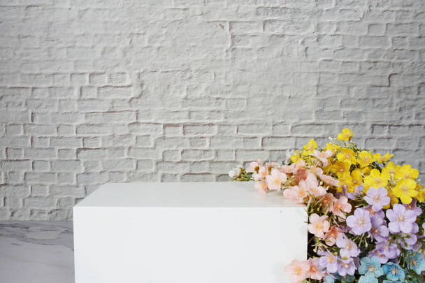 White squre podium with flower decoration for product display with white brick wall background - Foto, Bild