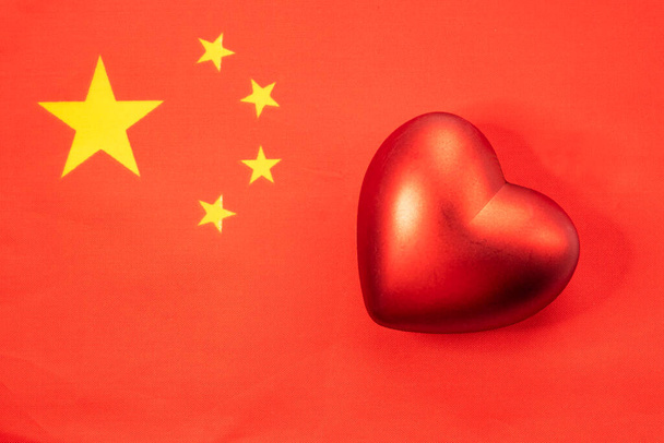 Червоне серце на прапорі Китаю. Поняття патріотичних почуттів до держави. Патріотизм - Фото, зображення