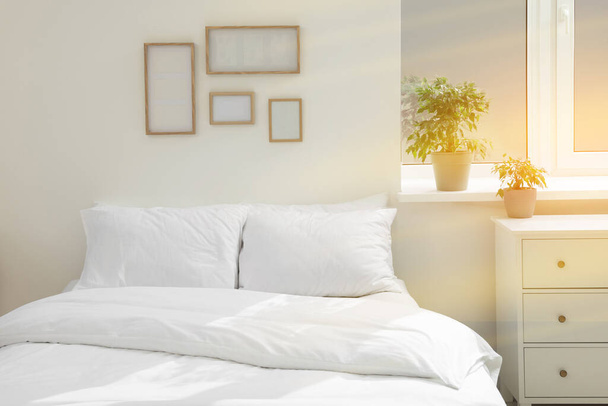 White soft pillows on cozy bed in room - Foto, afbeelding