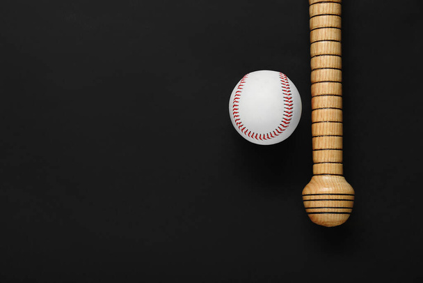 Wooden baseball bat and ball on black background, flat lay. Space for text - Foto, Imagen