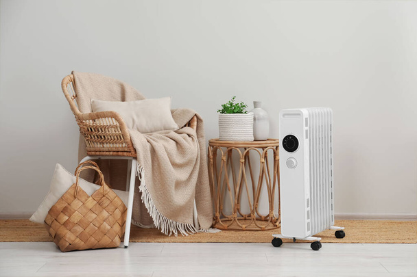 Modern portable electric heater near furniture indoors - Foto, afbeelding