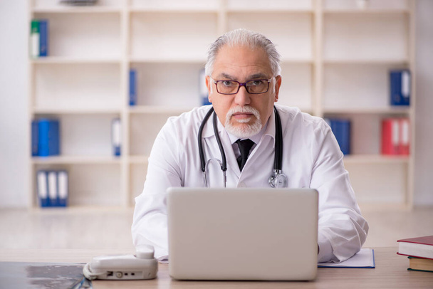 Aged male doctor in telemedicine concept - Photo, Image