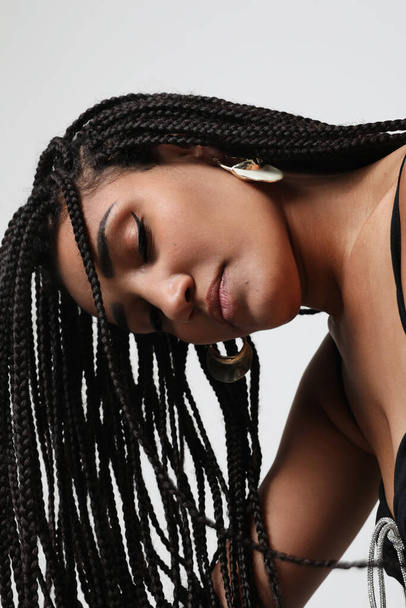 African American young woman with long dark braids, posing indoor. Mock-up. High quality photo - Zdjęcie, obraz