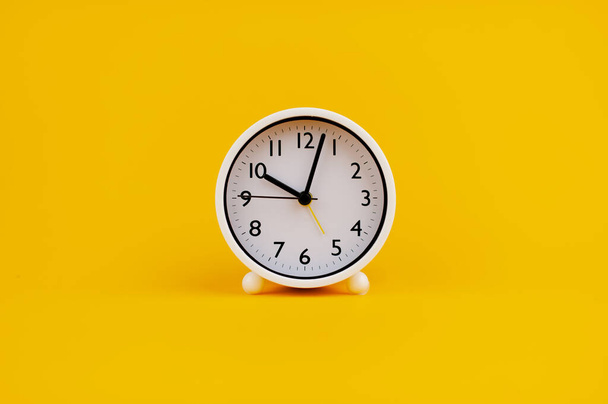 reloj blanco sobre fondo amarillo concepto de tiempo Planificación del tiempo - Foto, imagen