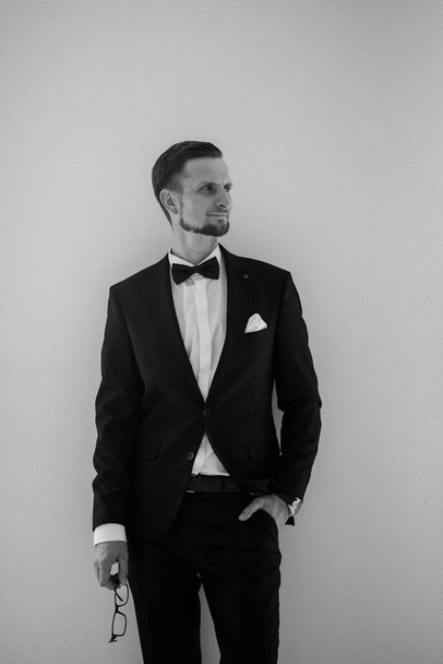 groom in a black suit with a bow tie in a bright studio - Foto, Imagem