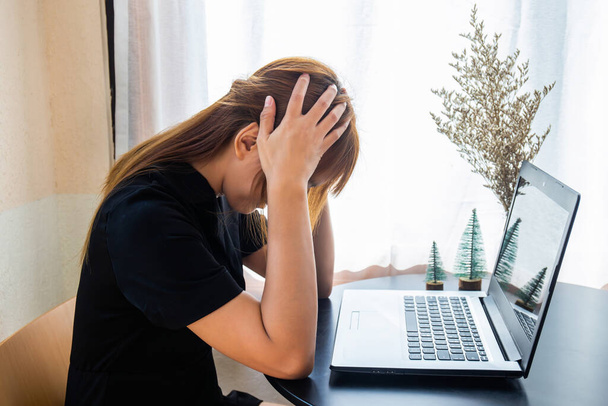 transparente, schwarz gekleidete Geschäftsfrau benutzt einen Laptop, um stressig zu arbeiten. - Foto, Bild