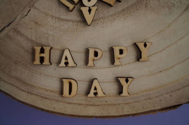Μπάνερ. Η λέξη Χαρούμενη Μέρα. Αγάπη σε ξύλινα τετράγωνα. Θέμα αγάπης. Ξύλινα γράμματα. Ερωτικά, θετικά συναισθήματα. - Φωτογραφία, εικόνα