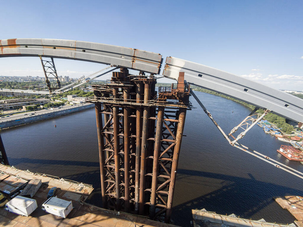 Ukraine, Kiew 5. Juni 2016: Eine große unvollendete Podilskyj-Brücke über den Dnipro. Riesige rostige Konstruktion. Bauindustrie. - Foto, Bild
