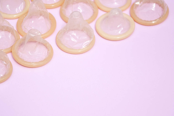 Wiele białych opakowań nieotwartych prezerwatyw na różowym tle. Koncepcja bezpiecznego seksu i zdrowia reprodukcyjnego. - Zdjęcie, obraz