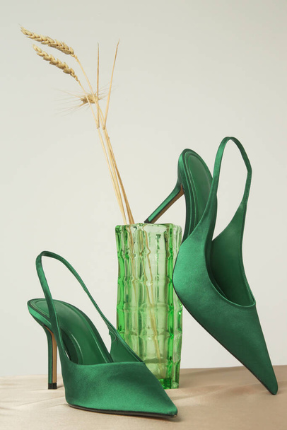 Kreatywny strzał studio z zielonymi satynowymi obcasami procy z klasycznym szpiczastym palcem, fotografia produktu - Zdjęcie, obraz