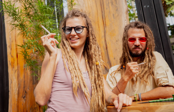 Hippie style couple smoking cigarettes with medical marijuana. - Foto, Imagem