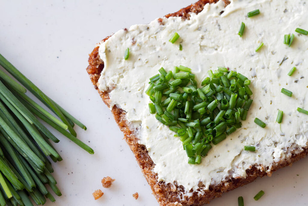 Sandwich with cream cheese and heart-shaped chives, concept  - Фото, изображение