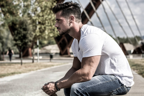 Attractive man in urban setting in front of big metal structure - Photo, image