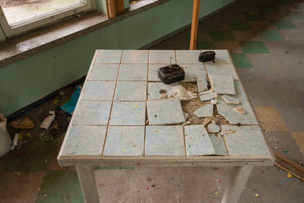 Старі, розкладені столики та кавові столи в покинутій будівлі
. - Фото, зображення