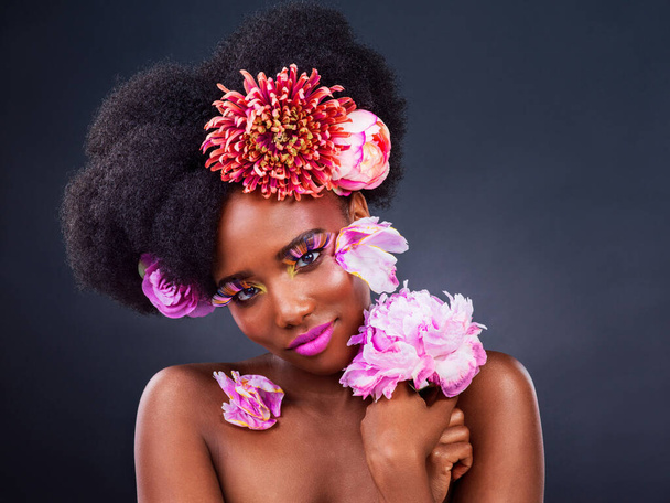 Blumen ist das einzige Accessoire, das Sie brauchen. Studioaufnahme einer schönen jungen Frau, die mit Blumen im Haar posiert - Foto, Bild