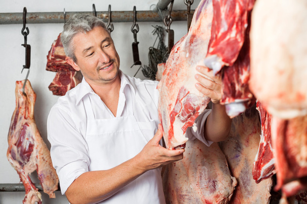 Butcher Checking Quality Of Meat In Butchery - Foto, immagini