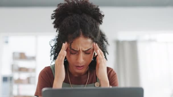 Woman, laptop and headache in burnout, stress or overworked in small business at fashion workshop. Stressed female suffering with bad head pain, ache or strain by computer at office desk in retail. - Footage, Video