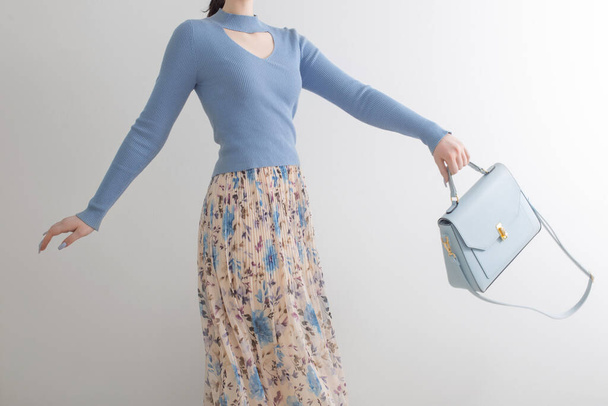 young girl in blue blouse  and pleated skirt with blue handbag on white background - Foto, Imagem