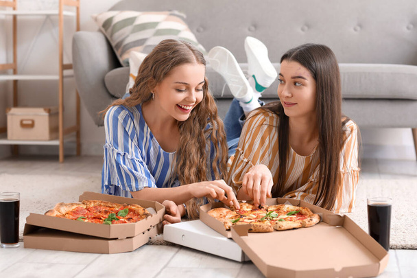 Young women eating tasty pizza at home - Foto, Imagem
